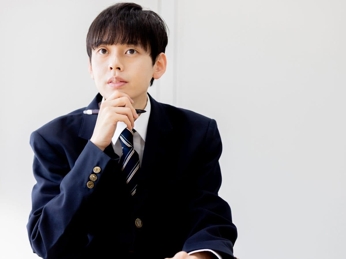 ペンを手に考えている高校生